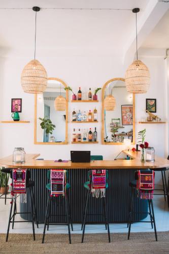 a kitchen with a large wooden bar with pink chairs at Baan Pila in Luang Prabang