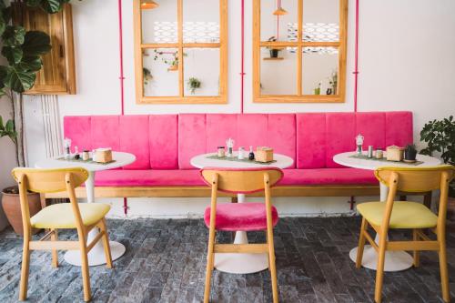 a pink bench with two tables and two chairs at Baan Pila in Luang Prabang