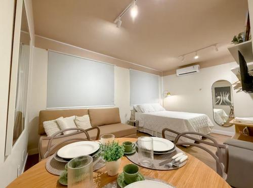 a living room with a table and a bed at StudioAconchego portaria 24h, elevador e garagem in Brasilia