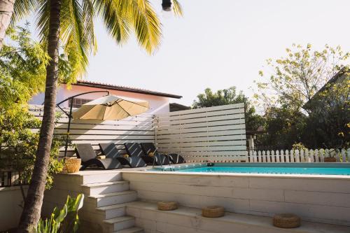 a swimming pool with lounge chairs next to a house at Baan Pila in Luang Prabang