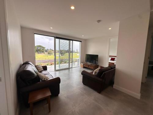 a living room with two couches and a flat screen tv at Private Getaway - Portarlington! in Portarlington