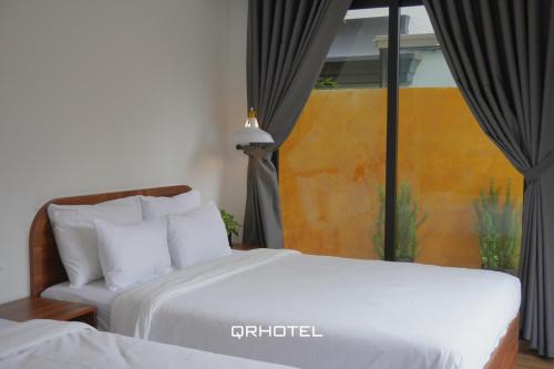 a hotel room with a bed and a window at QR Hotel Dalat in Xuan An