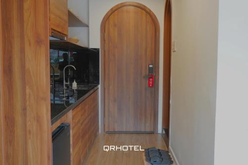 a kitchen with a wooden door in a kitchen at QR Hotel Dalat in Xuan An