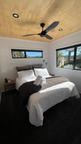a bedroom with two beds and a ceiling fan at On James in Coromandel Town