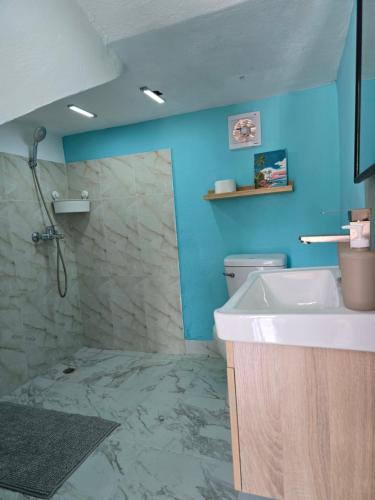 a bathroom with a sink and a shower with blue walls at Rest in Paradise, Pool, Beach and Terrace in Sánchez