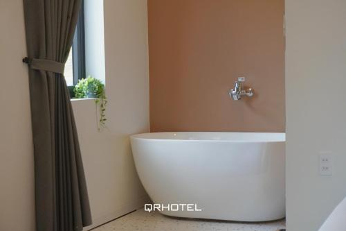 a bathroom with a white tub and a sink at QR Hotel Dalat in Xuan An