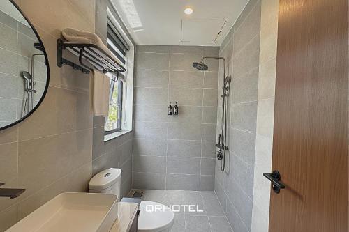a bathroom with a shower and a toilet and a sink at QR Hotel Dalat in Xuan An
