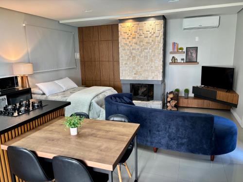a living room with a blue couch and a fireplace at Loft Piscina Privada Gramado in Gramado