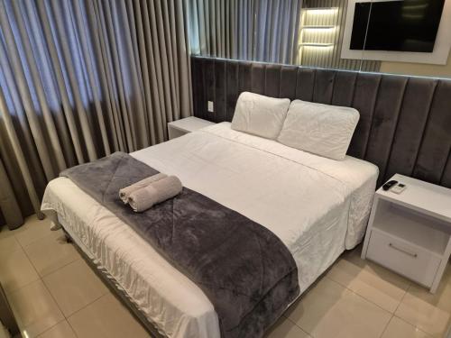 a hotel room with a bed with a towel on it at Flat Luxo Golden Ingá - Centro, Ao Lado Shopping in Maringá