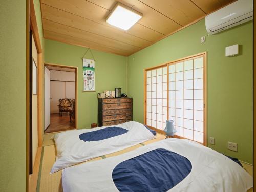 a bedroom with a bed in a room with green walls at Apollon in Gujo
