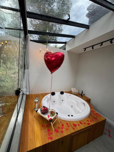 a room with a bath tub with a heart balloon at Loft com Piscina Privativa in Gramado