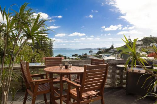a table and chairs on a patio with a view of the ocean at Tapeka View Unit in Russell
