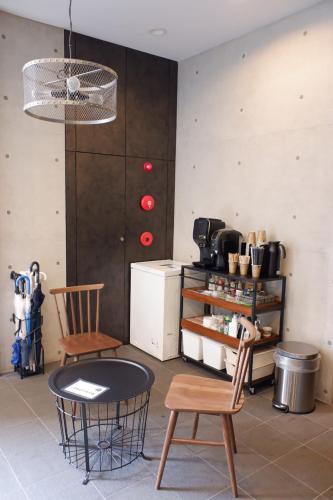 a room with two chairs and a table and a counter at TAKETO STAY Osakajo in Osaka
