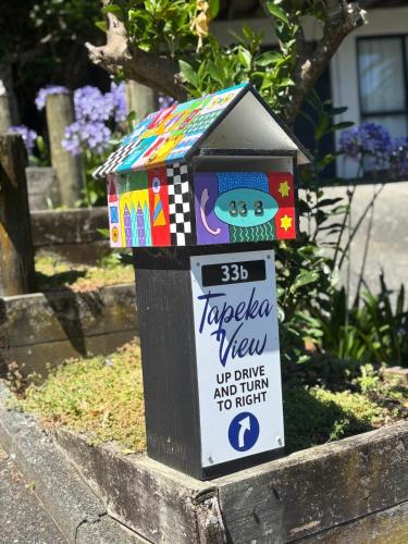a colorful bird house with a sign on it at Tapeka View Unit in Russell