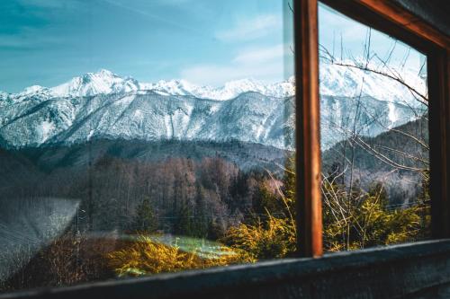a view of a snowy mountain range from a window at Yamabo inn 古民家 Traditional Japanese Home in Omachi