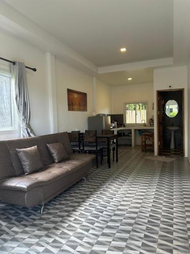a living room with a couch and a dining room at Enda Lanta Bungalows in Ko Lanta