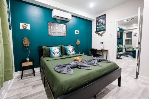 a bedroom with a bed with a blue wall at Perch in Paradise EaglesThemed Escape in Philadelphia