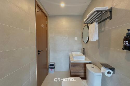 a small bathroom with a toilet and a sink at QR Hotel Dalat in Xuan An