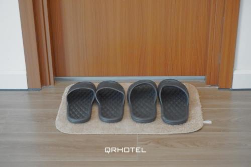 two pairs of shoes sitting on a mat in front of a door at QR Hotel Dalat in Xuan An