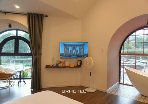 a living room with two large windows and a table at QR Hotel Dalat in Xuan An