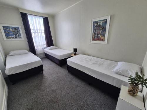 a room with two beds and a window at Royal Hotel Opotiki in Opotiki