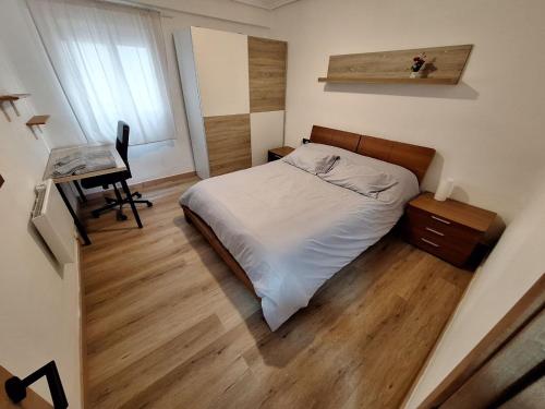 ein kleines Schlafzimmer mit einem Bett und einem Schreibtisch in der Unterkunft Piso Burjassot - Valencia in Burjasot