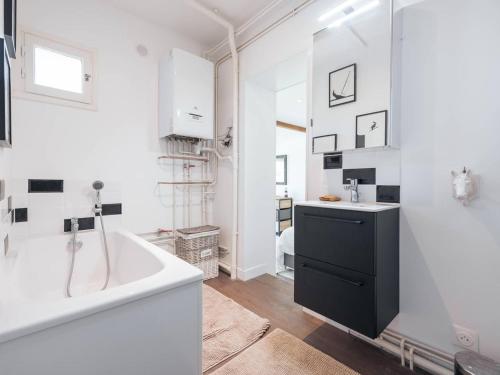 une salle de bain avec une baignoire et un lavabo dans l'établissement Maison spacieuse avec jardin et animaux admis - FR-1-821-42, à Le Touquet-Paris-Plage