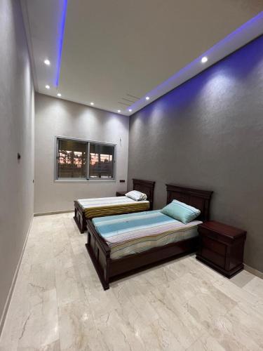 two beds in a room with blue lights at Farm with villa and pool in Settat
