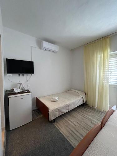 a small room with two beds and a television at Korčula Guest House in Korčula