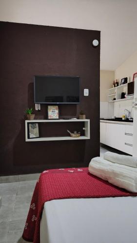 a bedroom with a black wall with a flat screen tv at Comodidades na Estrada do Coco in Camaçari