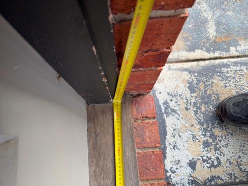 a yellow ruler on the side of a brick wall at McDougall Hidaway in Magpie