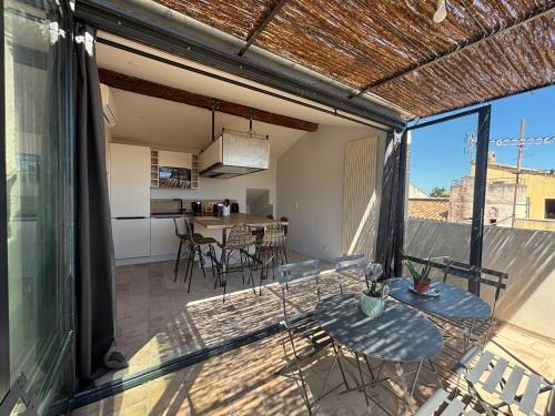 un patio ouvert avec tables et chaises sur un balcon dans l'établissement ARLES: Duplex Chic Centre - Clim & Vue Imprenable - FR-1-765-29, à Arles
