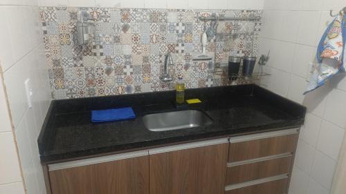 a kitchen with a sink and a tile wall at 2 bedrooms 2 bathrooms shopp beach wifi in Vila Velha