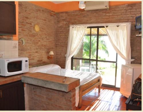 a kitchen with a bed and a microwave in a room at Del Barranco in San Gregorio de Polanco