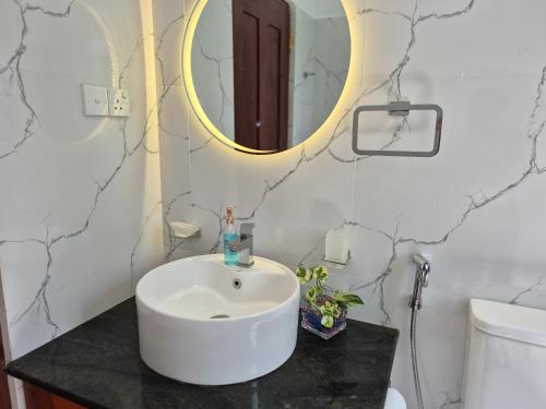 a bathroom with a sink and a mirror at Eco Rich Villa in Pamunugama