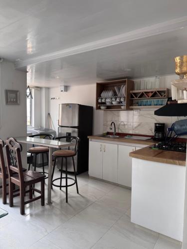 a kitchen with white cabinets and bar stools at Apartamento Caribe Coveñas 102 in Coveñas