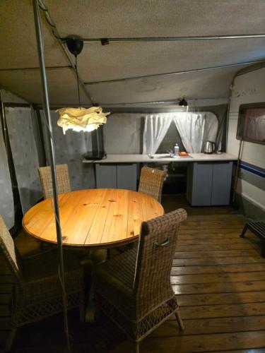 a wooden table in a room with chairs and a kitchen at Camping - Park Władysławowo in Władysławowo