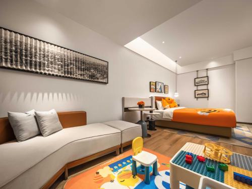 a room with a bed and a couch and a table at Grand Madison Wuhan Hankou on the Bund in Wuhan