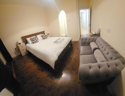 a bedroom with a large bed and a couch at Listowel Town in Listowel