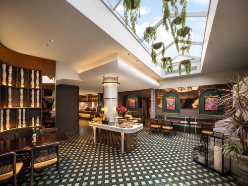 a lobby of a restaurant with a table and chairs at Grand Madison Wuhan Hankou on the Bund in Wuhan