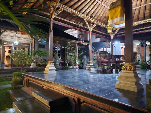 a lobby of a resort with a table and chairs at Nick's Homestay in Ubud