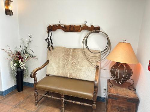 an old chair and a lamp in a room at Tombstone Grand Hotel, a Baymont by Wyndham in Tombstone