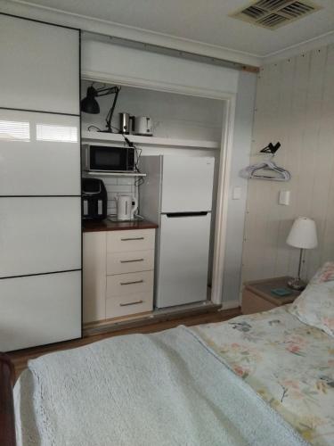 a bedroom with a bed and a kitchen with a microwave at Bamboo Rest in Rockingham