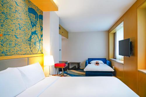 a hotel room with a bed and a tv at Radisson Collection Hyland Shanghai in Shanghai