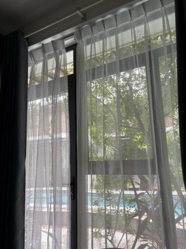 a window with white curtains in a room at Tam Coc Boutique Garden in Ninh Binh