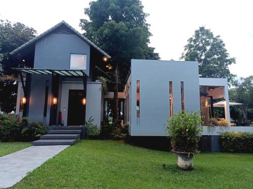a small house in a yard with a grass at Chombua MaeWang ชมบัว in Chiang Mai