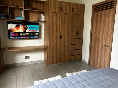 a bedroom with a flat screen tv and a bed at Apartamento completo planta baja Colonia Moderna in Guadalajara
