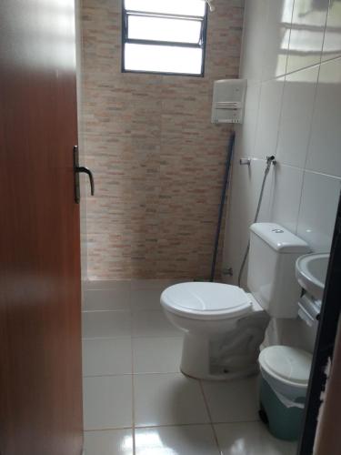 a bathroom with a toilet and a sink and a window at Sítio topo do Vale in Sabará