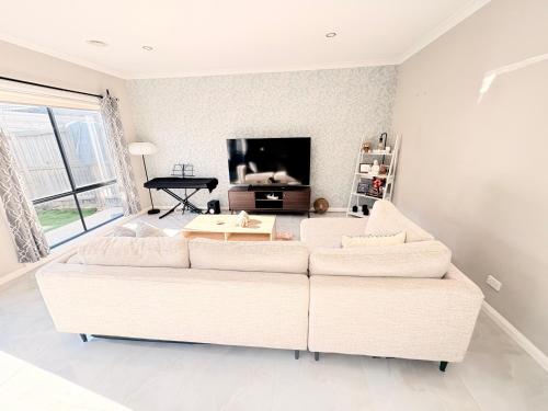 a living room with a white couch and a table at Kal's B&B in Clyde North