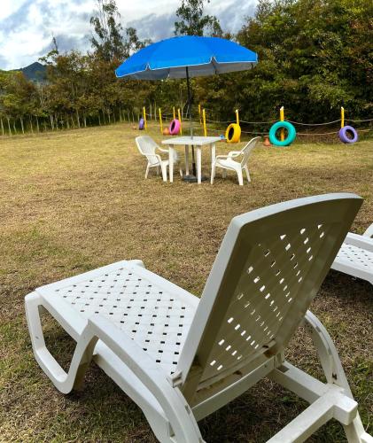 a picnic table and chairs with an umbrella and a playground at Ana Cereza Chalet in Nuevo Colón